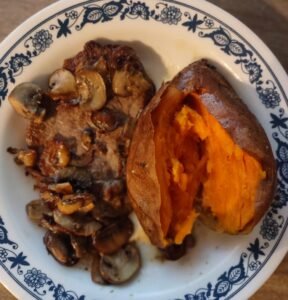 steak, fried mushrooms and a sweet potato