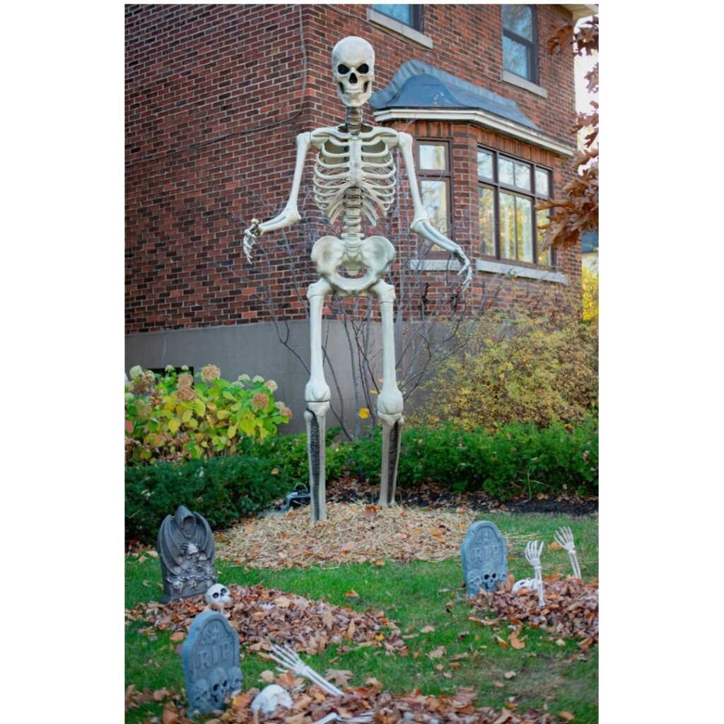 a skeleton and other halloween decorations in a yard in front of a house